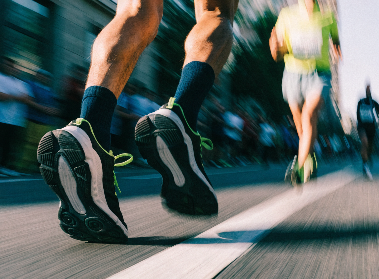 First marathon running shoes on pavement mid-stride
